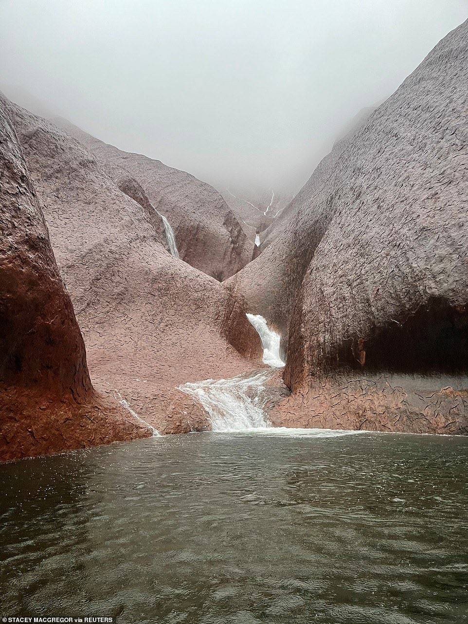 stunning pictures capture the moment water cascades down the sides of uluru readsector